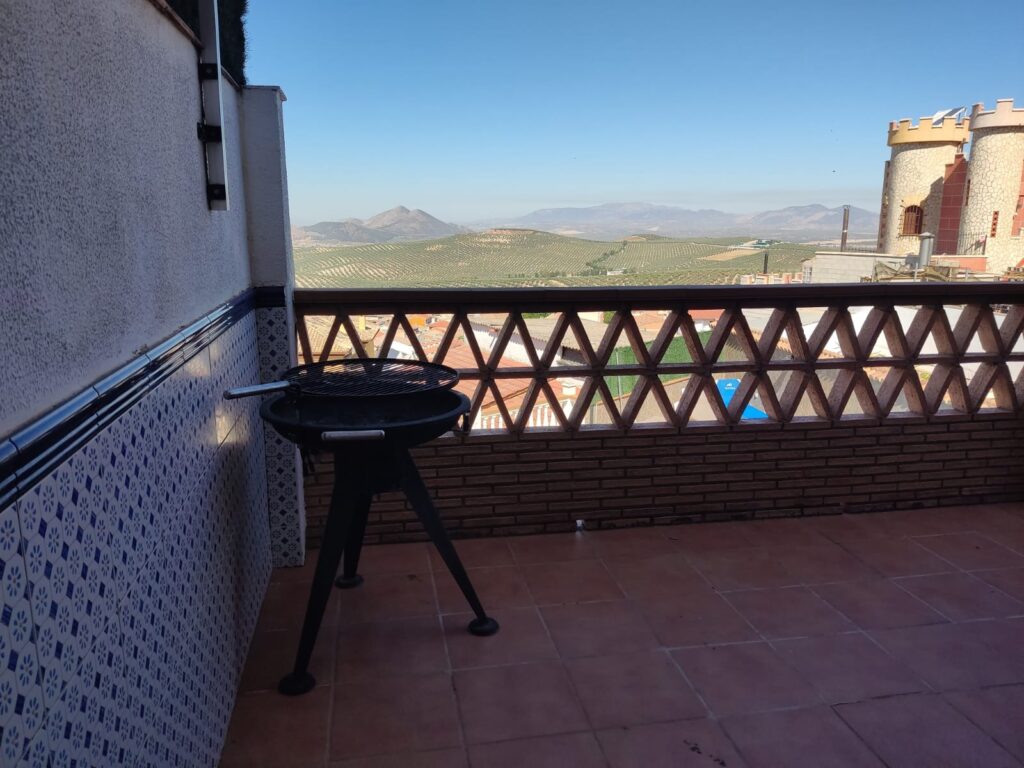 barbacoa exterior con mesas y vistas a la sierra