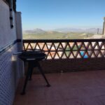 barbacoa exterior con mesas y vistas a la sierra