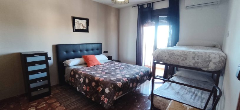 dormitorio con cama matrimonial y literas