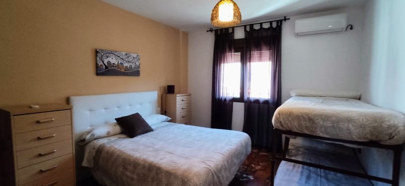 dormitorio con cama matrimonial y literas