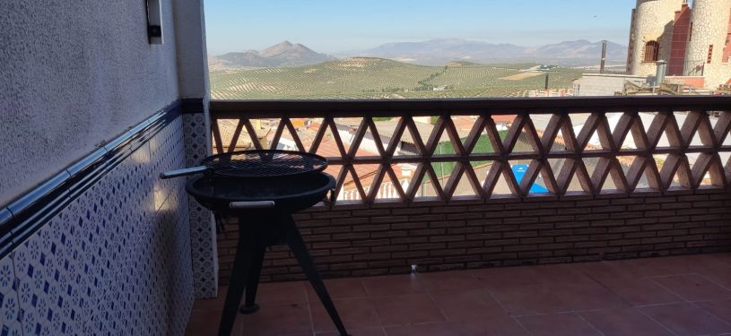 barbacoa exterior con mesas y vistas a la sierra